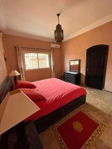 a bedroom with a red bed and a mirror at Triplex & Pool Tiguert in Agadir