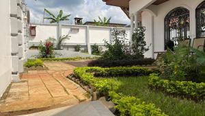 una casa con un jardín delante de ella en PEACE GUEST HOUSE en Yaundé