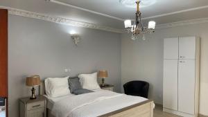 a bedroom with a bed and a chandelier at PEACE GUEST HOUSE in Yaoundé