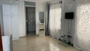 a bathroom with a mirror and a television in a room at PEACE GUEST HOUSE in Yaoundé +65 photos