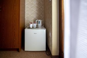 a small white refrigerator sitting in a room at Sobe Ličef in Bohinj