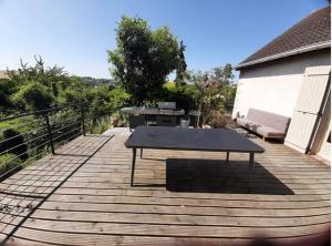 a wooden deck with a table and a bench on it at Maison confort et repos in Crecy la Chapelle