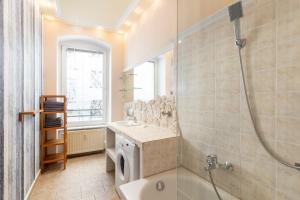 ein Badezimmer mit einer Dusche, einem Waschbecken und einer Badewanne in der Unterkunft Apartments am Fernsehturm in Berlin