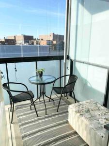 a table and two chairs on a balcony with a table and a tableablish at PASILA Modern flat centrally located in Helsinki