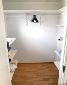 einen Schrank mit weißen Regalen und Holzböden in der Unterkunft PASILA Modern flat centrally located in Helsinki