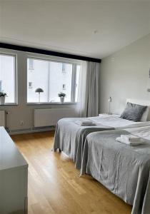 um quarto com uma cama grande e 2 janelas em Forenom Serviced Apartments Goteborg A-R Lorents Gata em Gotemburgo