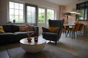 a living room with a couch and a coffee table at De Brittenburg 4-persoons, finse sauna, hottub, sunshower, grote zonnige omheinde tuin, wifi en huisdier vriendelijk in Lievelde
