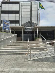 un edificio con escaleras y una bandera delante de él en Littoral Hotel, en João Pessoa