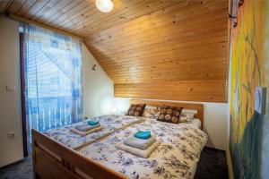 a bedroom with a large bed with a wooden ceiling at Sobe Ličef in Bohinj