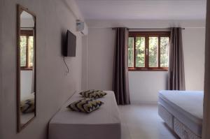 a hotel room with a bed and a mirror at Casas Porto Belo, um recanto a 100 metros da praia in Porto Belo