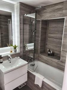 a bathroom with a tub and a sink and a shower at Brighton Apartment by Pier in Brighton & Hove