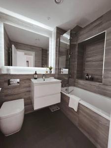 a bathroom with a toilet and a sink and a tub at Brighton Apartment by Pier in Brighton & Hove