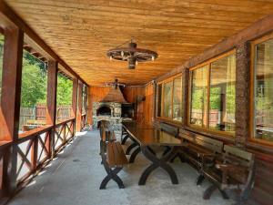 a porch of a house with a table and a fireplace at Cabana Ovidiu in Rau Sadului