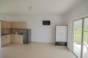 an empty kitchen with a refrigerator and a window at Villa Noel Borsh in Borsh