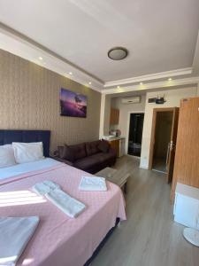 a bedroom with a large bed and a couch at RİXOS PERA Apartment in Istanbul