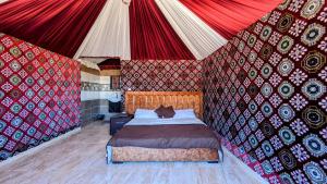 una camera da letto con un letto in una tenda di WhyDesert Camp & Tours a Wadi Rum Altre 14 foto
