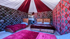 una habitación con 2 camas y una tienda de campaña en WhyDesert Camp & Tours, en Wadi Rum