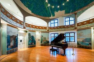 um quarto com um piano e pinturas nas paredes em Schloss Lautrach em Lautrach