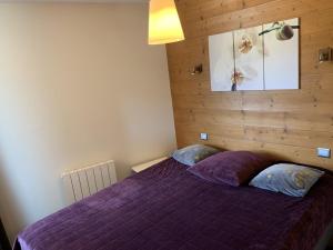 a bedroom with a purple bed with two pillows at Paradiski pied des pistes plan peisey in Peisey-Nancroix