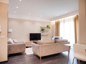 uma sala de estar com um sofá e uma televisão em Lake Drive Rooms&Apartments em Tirana
