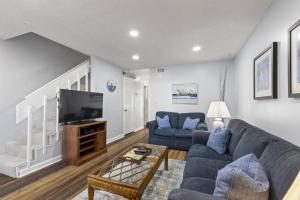 a living room with a couch and a tv at Coastal Haven Condo - Ormond Beach - Beach Access - Pool in Ormond-by-the-Sea