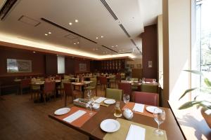 a restaurant with tables and chairs and a large window at Chisun Hotel Hamamatsucho in Tokyo