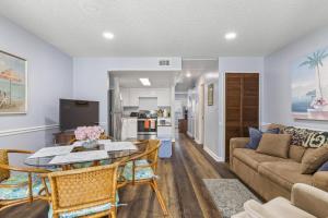 a living room with a couch and a table at Coastal Haven Condo - Ormond Beach - Beach Access - Pool in Ormond-by-the-Sea