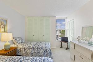 a bedroom with two beds and a television in it at Coastal Haven Condo - Ormond Beach - Beach Access - Pool in Ormond-by-the-Sea +41 photos