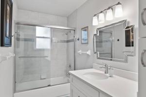a white bathroom with a sink and a shower at Palm Paradise Waterfront Home - Flagler Beach - Dock - Pet Friendly - Close To The Beach in Flagler Beach