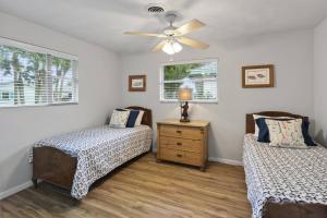 a bedroom with two beds and a ceiling fan at Palm Paradise Waterfront Home - Flagler Beach - Dock - Pet Friendly - Close To The Beach in Flagler Beach