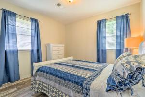 a bedroom with blue curtains and a bed and a dresser at Long Beach Hideaway Walk to Beach, Shops and Bars! in Long Beach