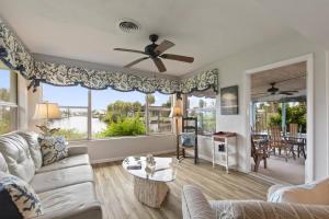 a living room with a couch and a ceiling fan at Palm Paradise Waterfront Home - Flagler Beach - Dock - Pet Friendly - Close To The Beach in Flagler Beach