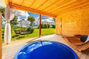 ブワディスワボボにあるDom Wczasowy Rudnik z basenem, sauną i baniąの木製パティオ(青い大型バスタブ付)