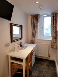 um quarto com uma mesa, um espelho e uma janela em Atlantic Seafront em Brighton & Hove