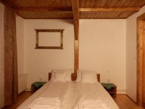 a bedroom with a large bed with white sheets at Casa din Zori in Muntele Băişorii