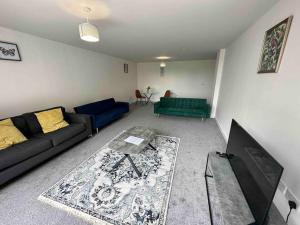 a living room with a couch and a tv at XL 2 Bed Central MCR Apt Sleeps 7 in Manchester