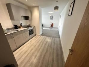 a kitchen with a wooden floor and a kitchen with a counter at XL 2 Bed Central MCR Apt Sleeps 7 in Manchester