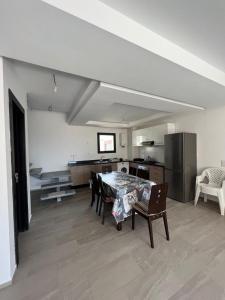 ein Wohnzimmer mit einem Tisch und Stühlen sowie eine Küche in der Unterkunft Duplex Taghazout Bay in Taghazout