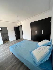 ein Schlafzimmer mit einem großen Bett mit blauer Bettwäsche in der Unterkunft Duplex Taghazout Bay in Taghazout