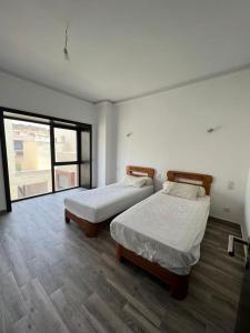 1 Schlafzimmer mit 2 Betten und einem großen Fenster in der Unterkunft Duplex Taghazout Bay in Taghazout