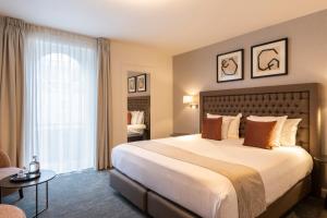 a hotel room with a large bed and a window at Dukes' Academie Brugge - by Dukes' Hotel Collection in Bruges