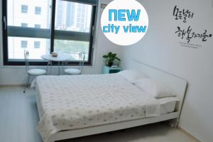 a bedroom with a bed with a new city view at For you House in Daegu