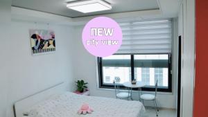 a bedroom with a new city view sign and a bed at For you House in Daegu
