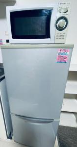 a microwave sitting on top of a refrigerator at STAR YONEGAHAMA l 米が浜通 in Kusugaurachō +3 photos