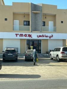 um homem andando em frente a um concessionário de carros em résidence zeineb em Nouakchott
