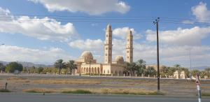 ein Gebäude mit zwei Kuppeln und zwei Minaretten in der Unterkunft Bahla Hotel Apartments in Bahlāʼ