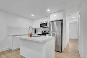 a kitchen with white cabinets and a stainless steel refrigerator at BRAND NEW Designer's Office Home #8 in Miami