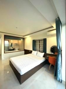 a bedroom with a bed and a desk and a window at Khách sạn Thiên Minh - Dốc Lết in My Luong