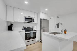 a white kitchen with a stove and a sink at BRAND NEW Designer's Office Home #8 in Miami