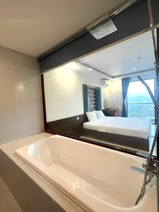 a large bath tub in a room with a bed at Khách sạn Thiên Minh - Dốc Lết in My Luong